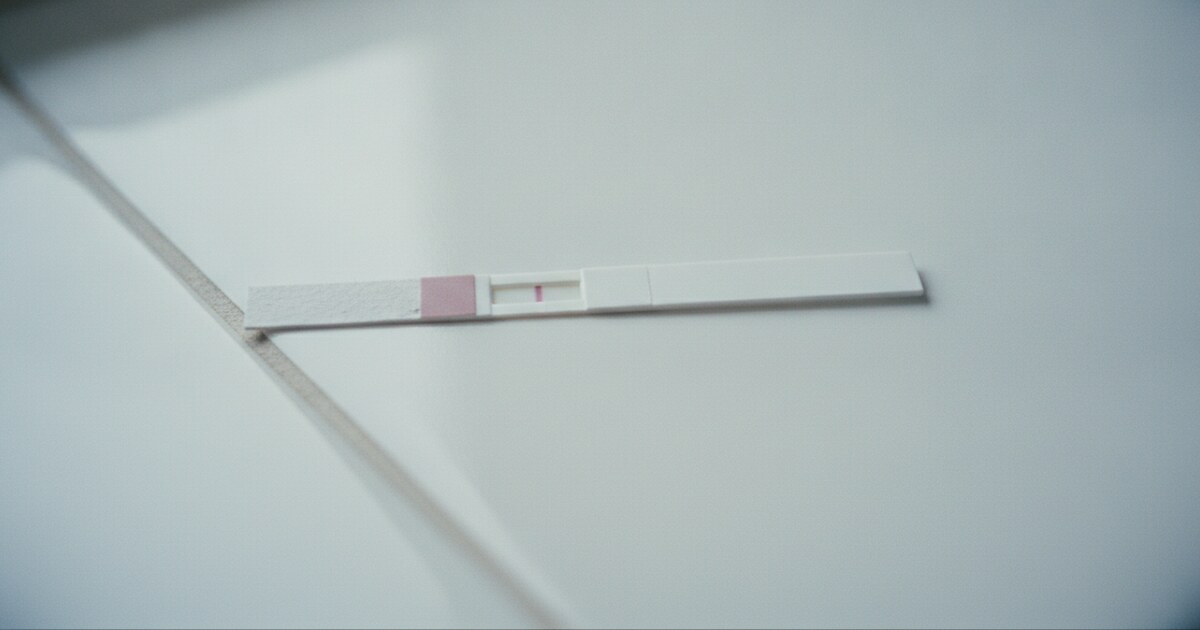 Home pregnancy test strip showing a single faint control line against a white background